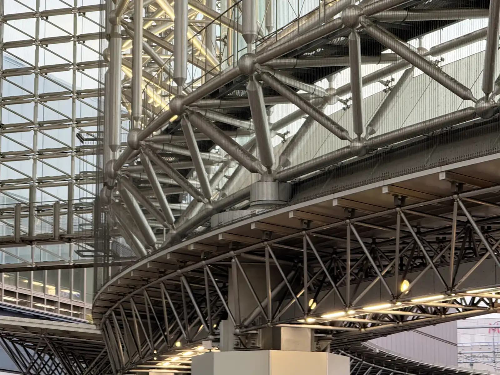Close-up of the steel truss framework holding up the Motenashi Dome roof, with lights fixed along the curved underside.