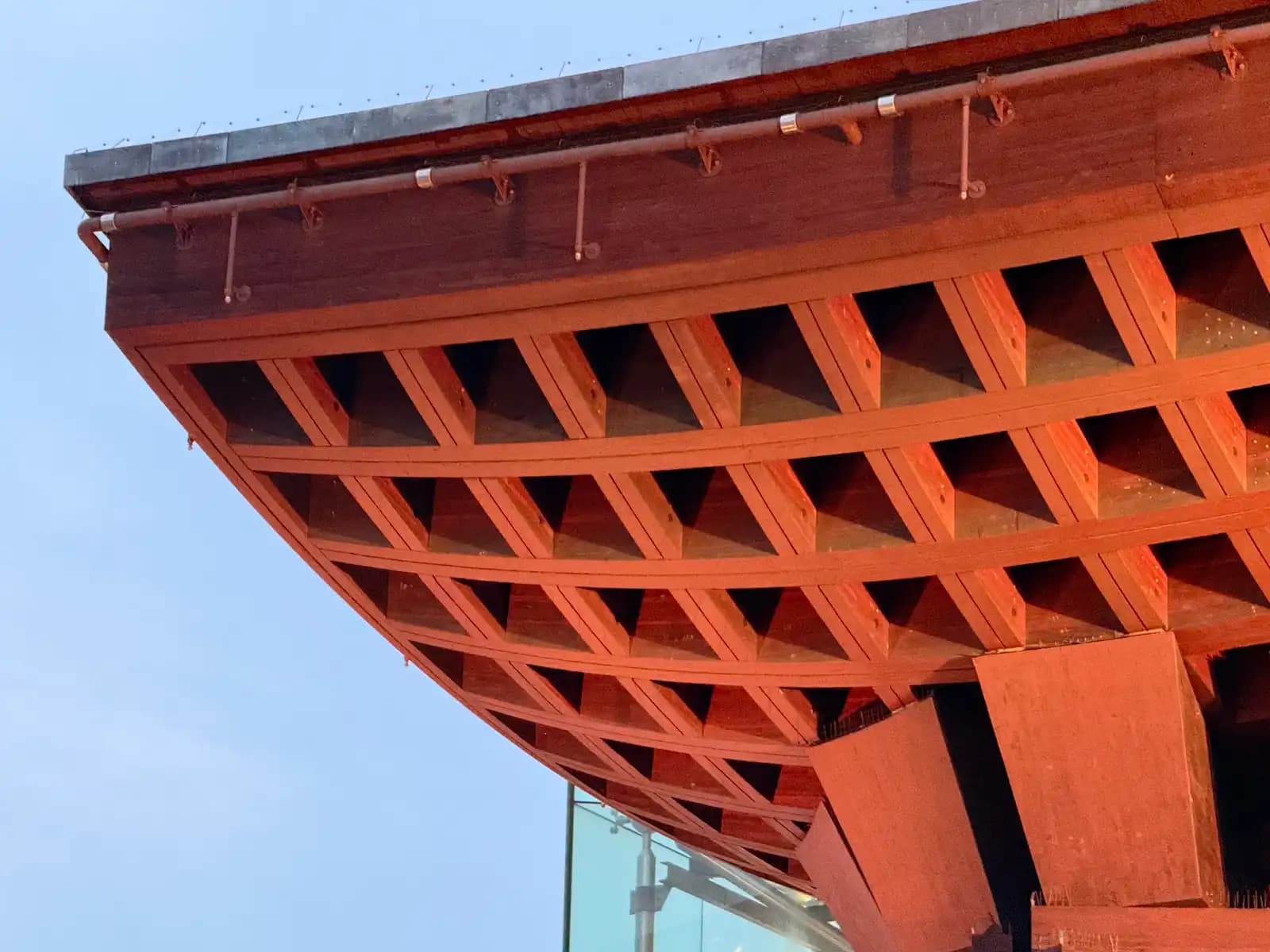 The corner of the Tsuzumi Gate's roof, showing the grid of wooden beams on the underside and a copper gutter along the edge.