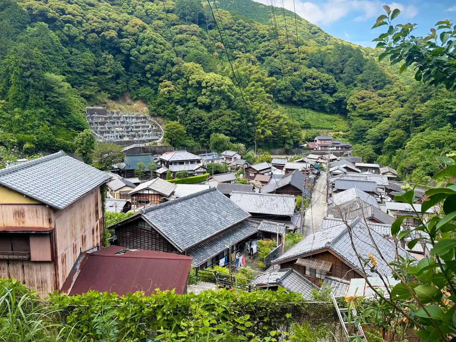 A wider view over the whole village in the valley, with a cemetery set into the hillside.