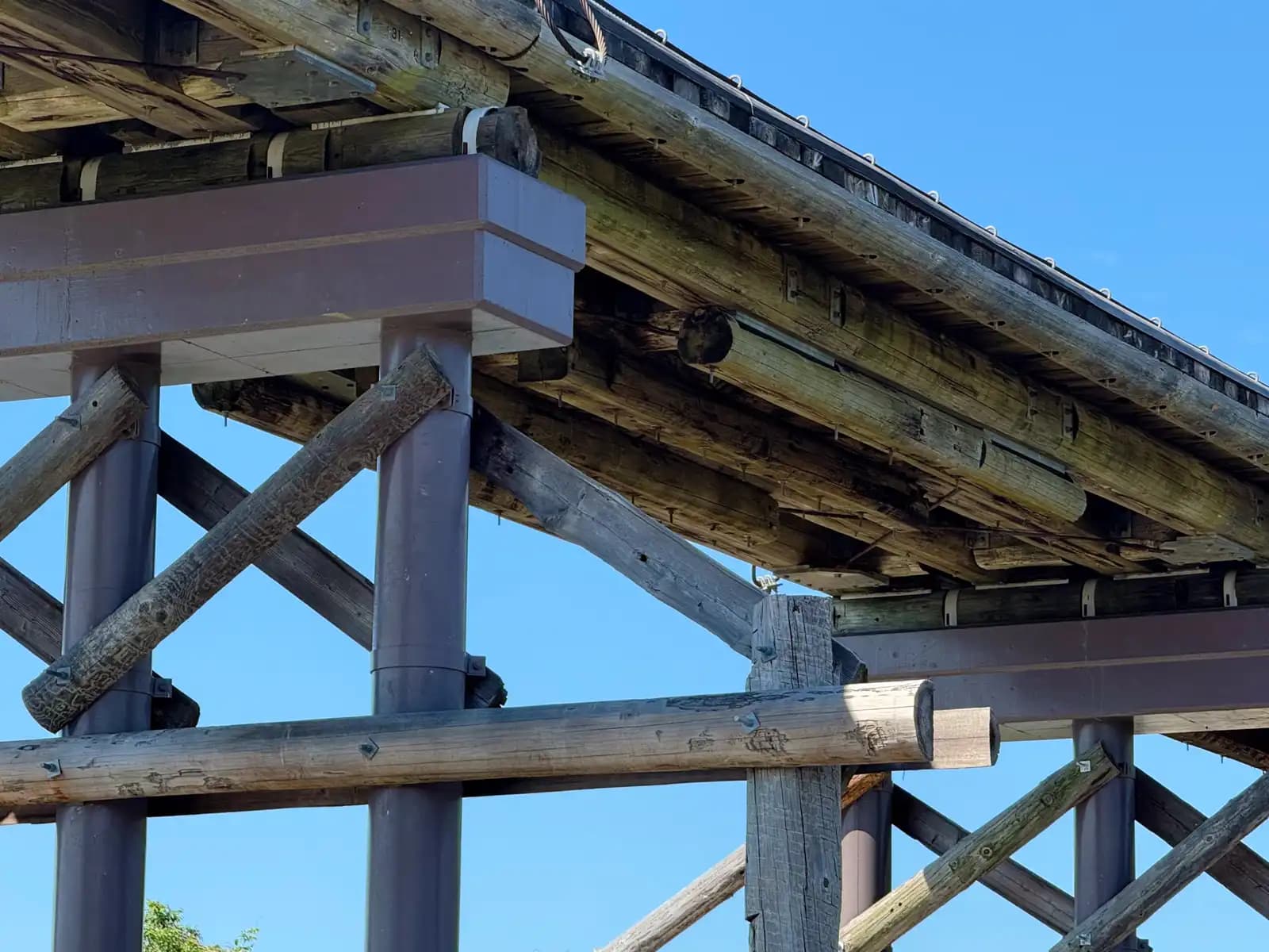 Underneath: the squared girders and cross-braced pier cap that carry the deck. Everything is pinned and cabled so sections can be lifted back into place after a flood.