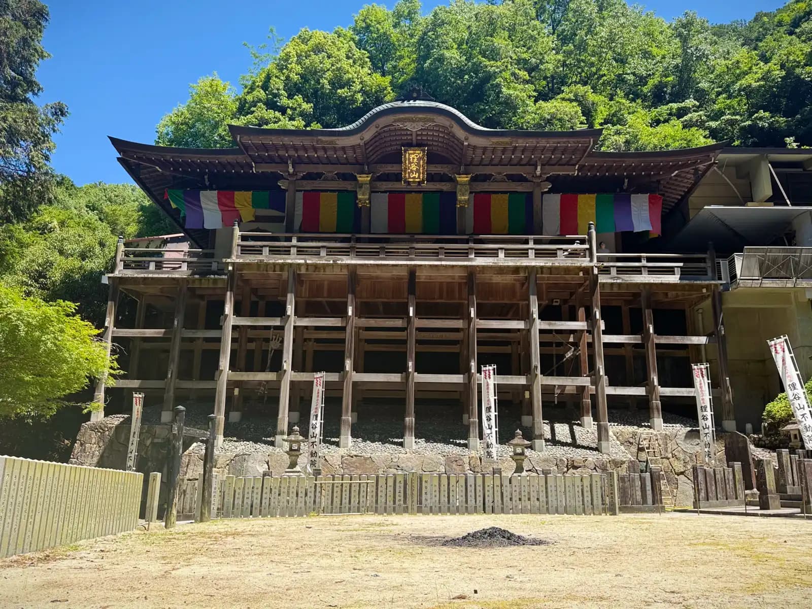 The main hall seen from the sand court below, its five-color Buddhist banners hung across the front.