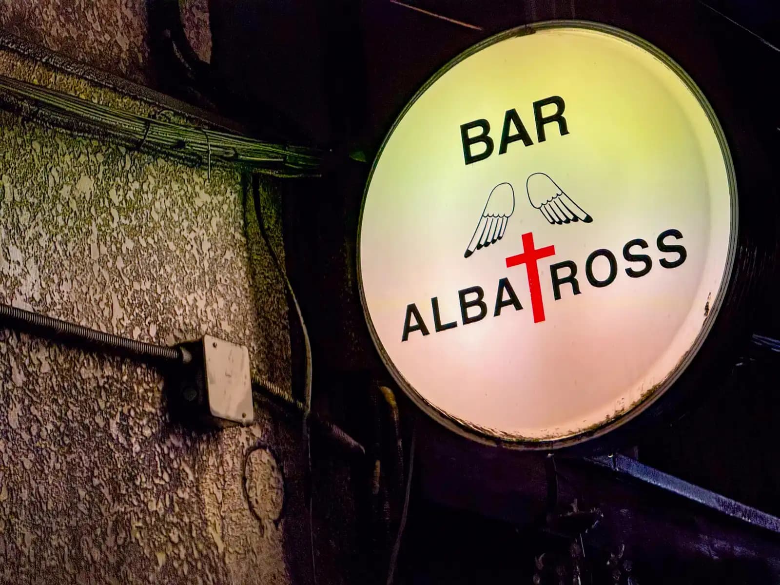 The round lit-up sign for Bar Albatross.