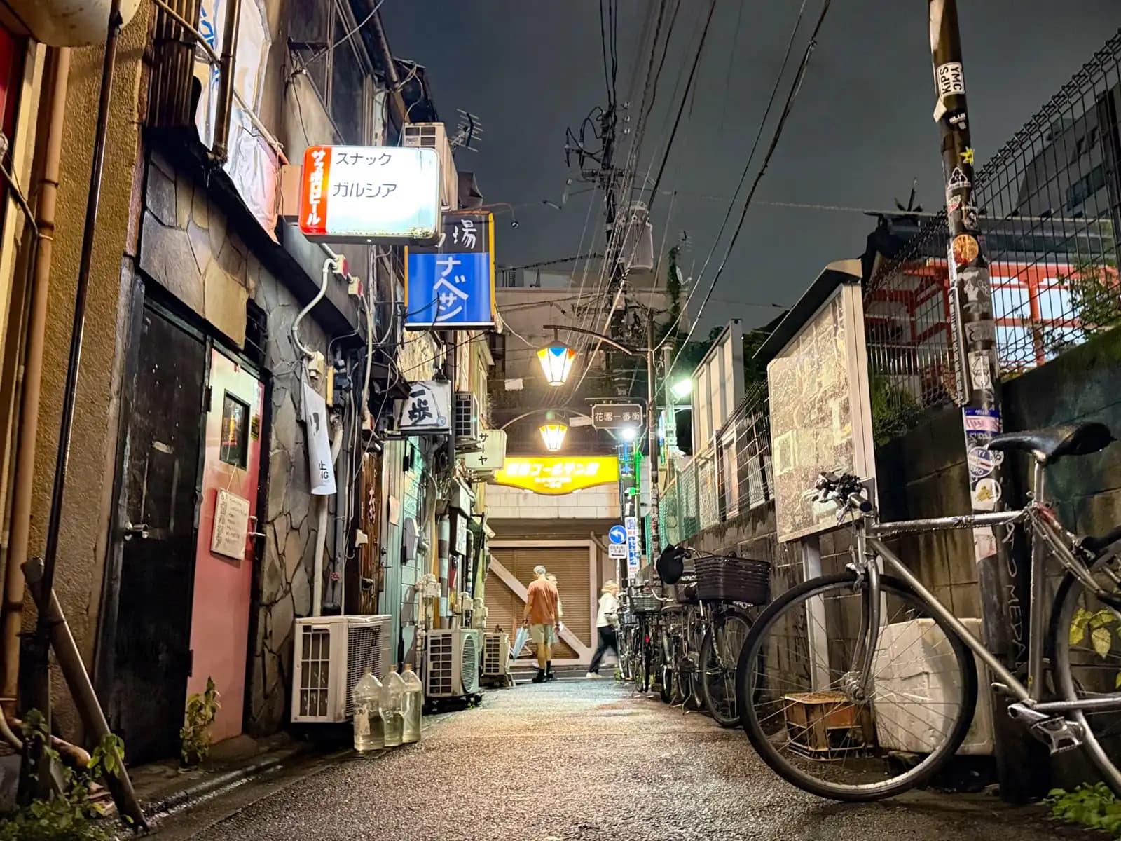 Snack Garcia and Nabesan on the left, bikes lined up on the right, and the Golden Gai sign at the end of the lane.