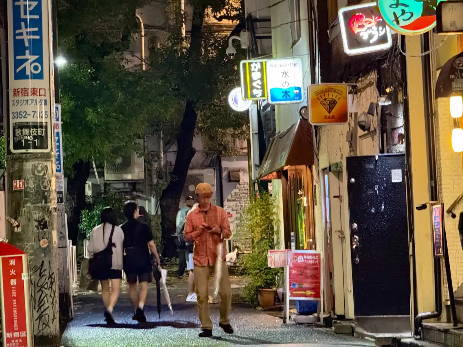 People walking past a row of small bars.